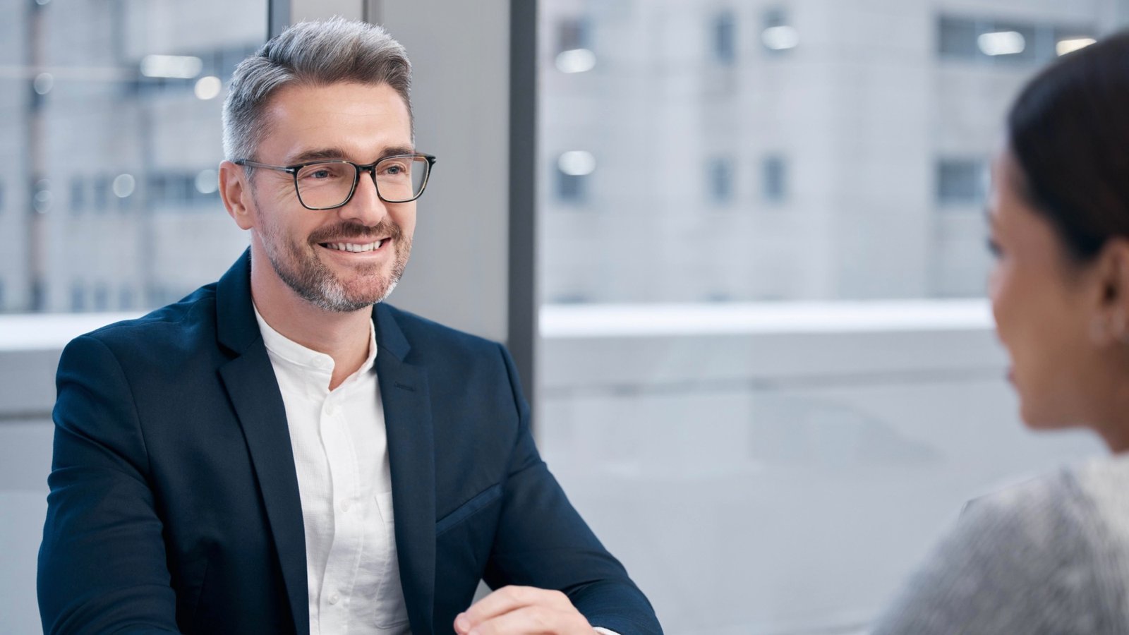 Bewirbdich.ch: Bestmöglich vorbereitet ins Bewerbungsgespräch gehen. Lächelnder Mann im Sakko im Gespräch – Vorbereitung auf das Job-Interview